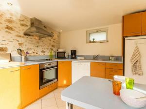 uma cozinha com armários laranja e um forno com placa de fogão em Gîte Saint-Brevin-les-Pins, 3 pièces, 4 personnes - FR-1-306-1031 em Saint-Brévin-les-Pins