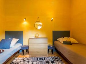 um quarto com 2 camas e uma parede amarela em Gîte Saint-Brevin-les-Pins, 3 pièces, 4 personnes - FR-1-306-1031 em Saint-Brévin-les-Pins