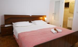 duże łóżko z dwoma pluszakami siedzącymi na nim w obiekcie Apartments Boro w mieście Splitska
