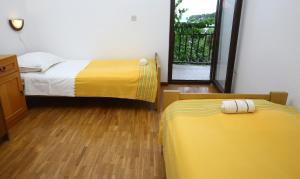 sypialnia z 2 łóżkami z żółtą pościelą i oknem w obiekcie Apartments Boro w mieście Splitska