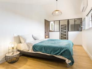 ein weißes Schlafzimmer mit einem großen Bett und einer Lampe in der Unterkunft Gîte Saint-Hilaire-de-Clisson, 3 pièces, 5 personnes - FR-1-306-904 in Saint-Hilaire-de-Clisson