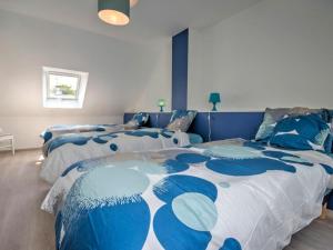 una camera con due letti con lenzuola blu e bianche di Gîte Herbignac, 4 pièces, 7 personnes - FR-1-306-1105 a Herbignac