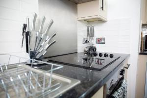 a kitchen with a counter with knives on it at Modern Townhouse Apartment with FREE Parking, Wifi & Netflix in Stratford-upon-Avon
