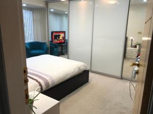 a bedroom with a bed and a chair and a television at Lyndon B&B in Birmingham