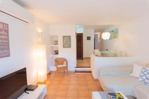 a living room with a white couch and a table at Apartamento Ferrera Park 603 in Cala Ferrera