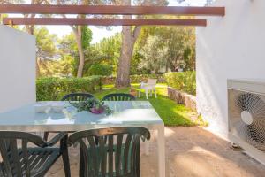 a patio with a table and chairs in a yard at Apartamento Ferrera Park 603 in Cala Ferrera