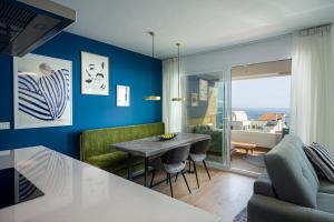 salon z niebieskimi ścianami, stołem i krzesłami w obiekcie Luxury Seaviews Calaceite Casasol w mieście Torrox Costa