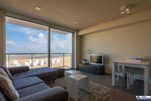 - un salon avec un canapé et une vue sur la plage dans l'établissement Alexy 0201, à Coxyde