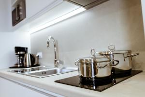 a kitchen counter with two pots on a stove at ANTEL Suites & Apartments in Chania