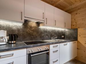 eine Küche mit weißen Schränken und einem Herd in der Unterkunft Apartment Talbach by Interhome in Laimach