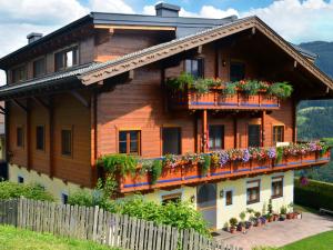 uma casa de madeira com flores nas varandas em Apartment Hinterkerschbaum - BRG105 by Interhome em Taxenbach