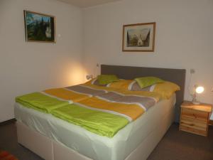 - une chambre dotée d'un grand lit avec des draps verts et orange dans l'établissement Apartment Eusch - SLB340 by Interhome, à Viehhofen
