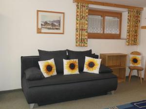 a black couch with three sunflower pillows on it at Apartment Eusch by Interhome in Viehhofen +16 photos