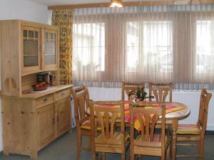 une cuisine avec une table et des chaises en bois, une table et des armoires dans l'établissement Apartment Eusch - SLB340 by Interhome, à Viehhofen