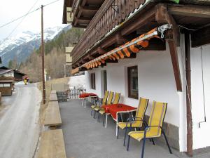 einen Tisch und Stühle an der Seite eines Gebäudes in der Unterkunft Holiday Home Kleewein - SOE215 by Interhome in Sölden