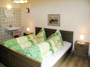 a bedroom with a bed with green and white pillows at Holiday Home Waldhof - SOE685 by Interhome in Im Brand