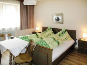 Schlafzimmer mit einem Bett mit grünen und weißen Kissen in der Unterkunft Holiday Home Waldhof - SOE685 by Interhome in Im Brand