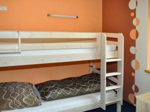 カップルにあるApartment Miramonte - KPL283 by Interhomeのオレンジ色の壁の客室の二段ベッド1台分です。
