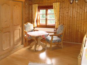 Zimmer mit 2 Stühlen, einem Tisch und einem Fenster in der Unterkunft Holiday Home Jagdhaus Strengen - SNN100 by Interhome in Oberriefen