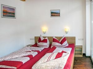 dwa łóżka w pokoju z czerwonymi i białymi poduszkami w obiekcie Apartment Diamant by Interhome w Solden