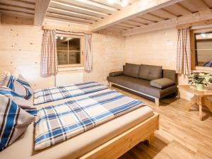 um quarto com uma cama e um sofá em uma sala em Chalet Grimmingblickhütte by Interhome em Unterlengdorf