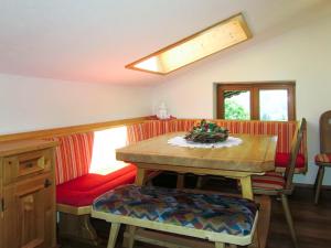 a dining room with a wooden table and red chairs at Apartment Bergkamerad - SLD550 by Interhome in Preunegg