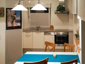 a kitchen with a table and chairs and a sink at Apartment Corona - RMU185 by Interhome in Ramsau am Dachstein