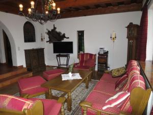 uma sala de estar com cadeiras vermelhas e uma mesa e uma televisão em Holiday Home Walcher - RMU220 by Interhome em Ramsau am Dachstein