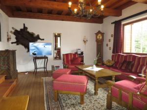 uma sala de estar com cadeiras vermelhas e uma televisão de ecrã plano em Holiday Home Walcher - RMU220 by Interhome em Ramsau am Dachstein