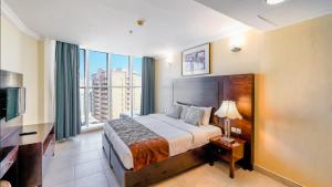 a hotel room with a bed and a large window at City Stay Residences - Serviced Apartments Al Barsha in Dubai