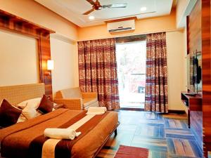 a hotel room with a bed and a window at Hotel Poonam in Mahabaleshwar