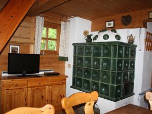 a living room with a tv and a desk with a television at Holiday Home Kunzhof - TFN110 by Interhome in Winklern