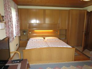 duże łóżko w pokoju z drewnianymi szafkami w obiekcie Apartment Lassnig - ARR101 by Interhome w mieście Arriach