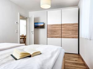 a bedroom with a bed with a book on it at Apartment Deutschbauer - FAK101 by Interhome in Egg am Faaker See