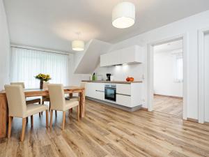 a kitchen and dining room with a wooden table and chairs at Apartment Deutschbauer - FAK101 by Interhome in Egg am Faaker See