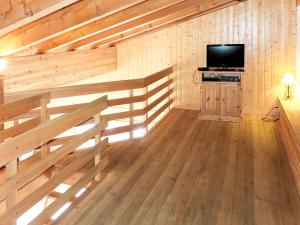 Habitación con paredes de madera y TV de pantalla plana. en Apartment Les Cîmes 8 by Interhome en Les Collons