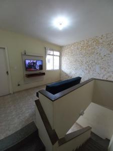 a living room with a couch and a tv on a wall at Apartamento Praiana 303 in Guarapari