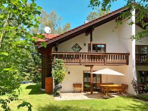 a house with a deck and a table with an umbrella at Holiday Home Birke by Interhome in Habischried