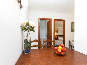 een tafel met een vaas met bloemen en een fruitschaal bij Apartment S'Esquirols I by Interhome in Begur