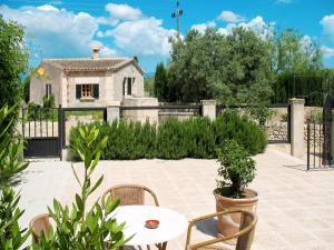 eine Terrasse mit einem Tisch und Stühlen sowie ein Haus in der Unterkunft Holiday Home Casita Roqueta - MDS100 by Interhome in Maria de la Salut