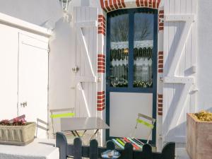 a porch with a blue door and a chair at Holiday Home Ty Tan-Nie by Interhome in Quiberon