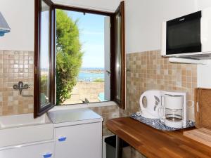 uma cozinha com uma janela e um balcão com um aparelho em Holiday Home Kereol by Interhome em Cléder