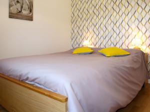 a bedroom with a bed with two yellow pillows at Apartment Ty Ménez - GLN105 by Interhome in Goulien