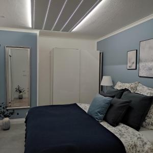 ゼンフテンベルクにあるAppartement Sterneの青い壁のベッドルーム1室(大型ベッド1台付)