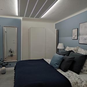 a bedroom with a large bed with blue walls at Appartement Sterne in Senftenberg +13 photos