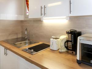 um balcão de cozinha com um lavatório e um micro-ondas em Apartment Le Soleil Camarguais - SMM151 by Interhome em Saintes-Maries-de-la-Mer