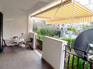 a patio with a table and chairs on a balcony at Apartman Stella in Fažana