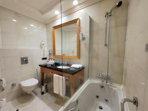 a bathroom with a toilet, sink and bathtub at Wyndham Grand İzmir Özdilek in İzmir