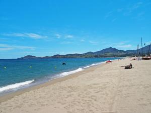 una playa de arena con el océano y las montañas en el fondo en Apartment Les Pins Parasols - AGL350 by Interhome, en Argelès-sur-Mer