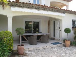 una casa con patio con mesa y sillas en Holiday Home Les Piboules - LLI150, en Callian